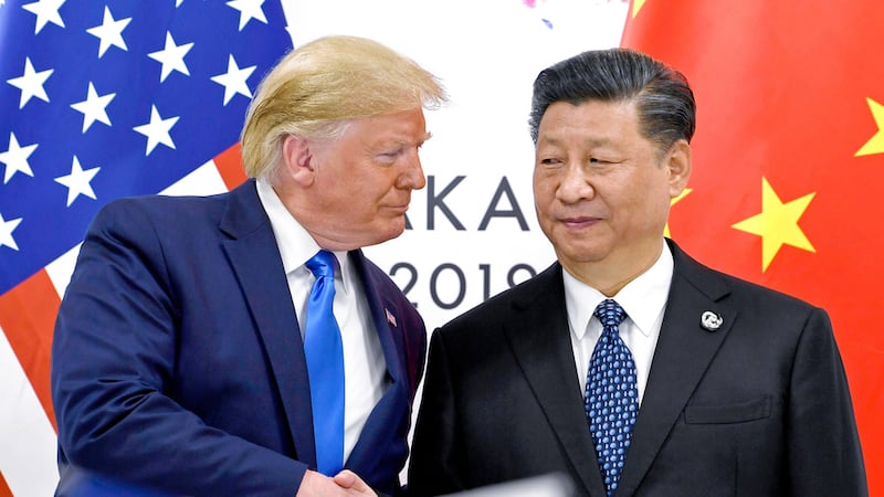 ARCHIVO - El presidente Donald Trump, izquierda, estrecha la mano de su homólogo chino Xi...