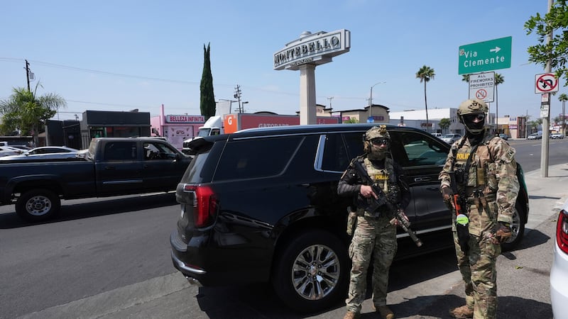 ARCHIVO - Agentes de inmigración durante una operación en un lavado de coches, el 15 de agosto...