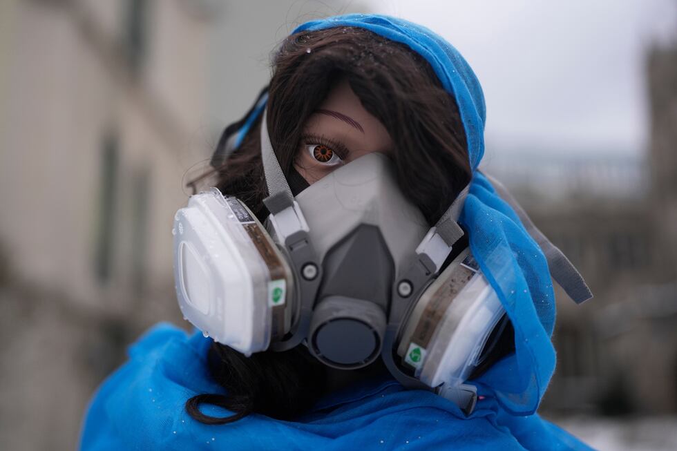 Un maniquí que representa a la Virgen María porta una máscara en la representación del pesebre...